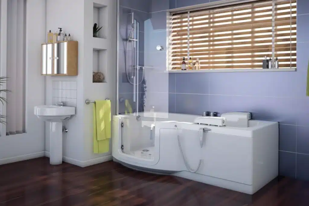 Modern bathroom with walk-in bathtub, blue tiles, and wooden blinds, featuring a sink and mirrored cabinet.