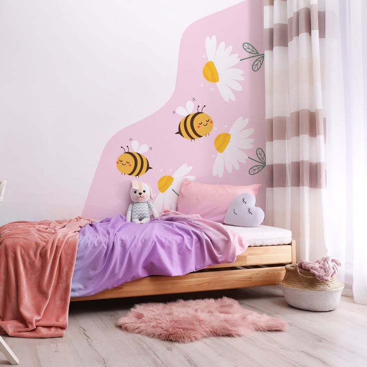 Cozy children's room with bee and flower wall art, soft blankets, and a plush toy on the bed.