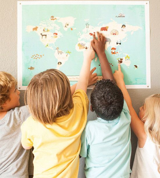 Children exploring a world map with animals, pointing and interacting, fostering curiosity and learning geography.