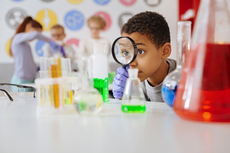 Curious child examining test tubes with a magnifying glass in a colorful chemistry classroom.