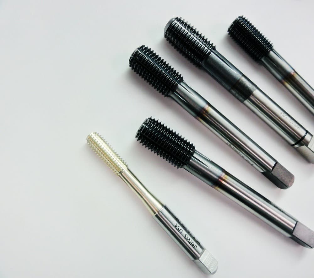 DSC08564 Various metal machine taps on a white background, showcasing threading tools for industrial use. | Sky Rye Design Various metal machine taps on a white background, showcasing threading tools for industrial use.