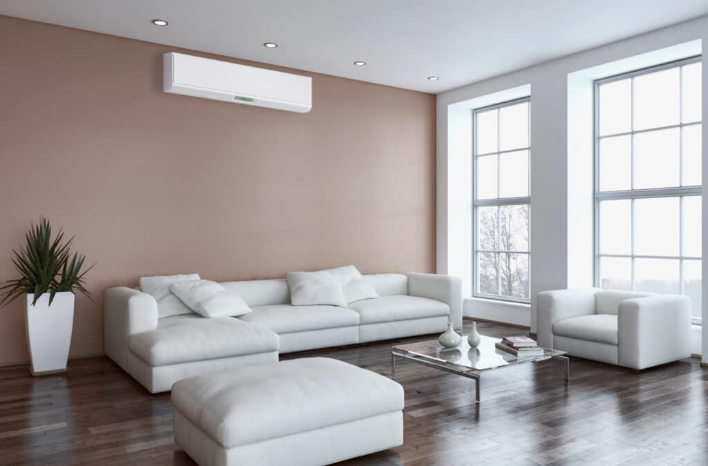 Modern living room with white furniture, wooden floor, large windows, air conditioning, and potted plant.
