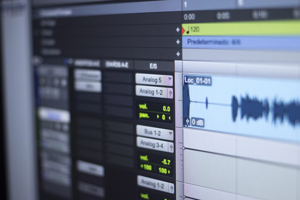 Audio editing software interface with sound waves and control panel for music production.