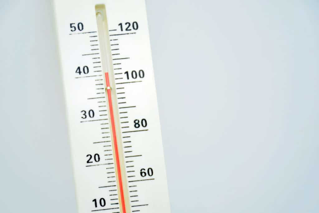 Close-up of a thermometer showing 40 degrees Celsius and 104 degrees Fahrenheit against a light background.