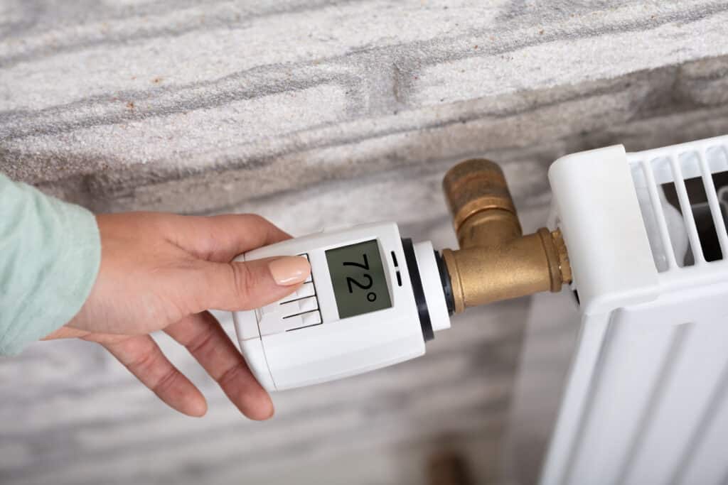 Person Adjusting Temperature On Radiator | Sky Rye Design