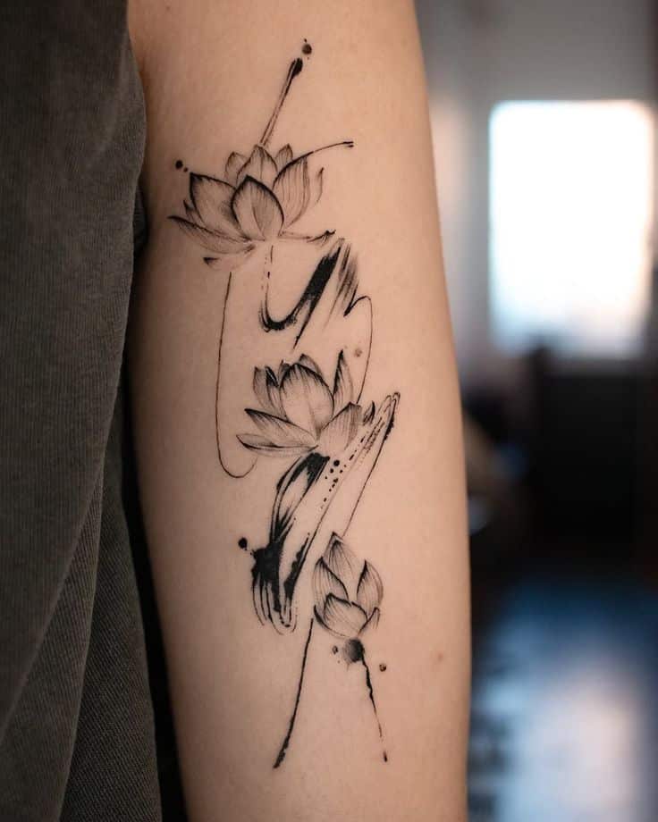 Minimalist ink tattoo of abstract flowers on a person's arm, featuring artistic strokes and blossoms.