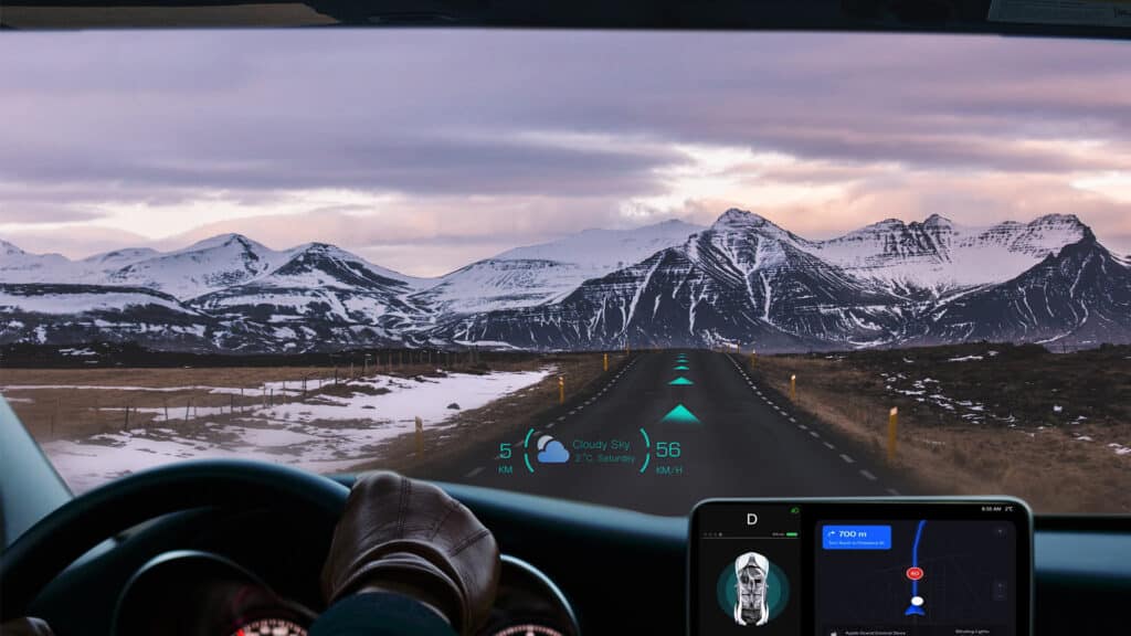 Driving through snowy mountains with futuristic HUD navigation display on windshield.