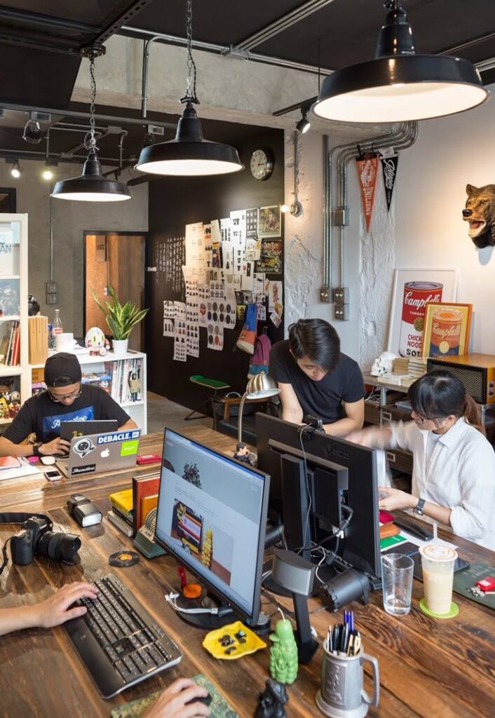 Modern creative office with team working on computers, surrounded by design elements and decor.