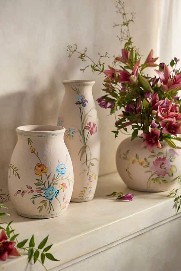 Decorative floral vases with fresh pink and purple flowers on a light surface, enhancing home decor.
