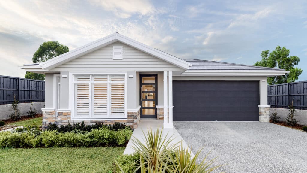 Modern single-story house with gray siding, dark garage door, and landscaped front yard.