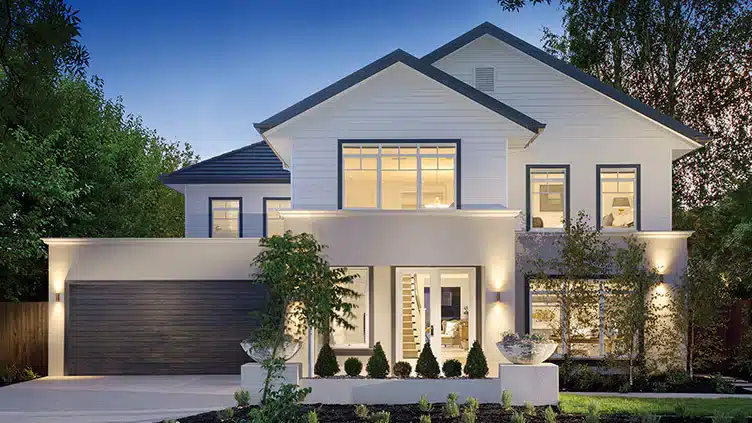 Modern two-story house with large windows, evening lights, and landscaped front yard.