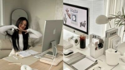 Woman working at a minimalist desk setup with iMac, planner, and iced coffee.