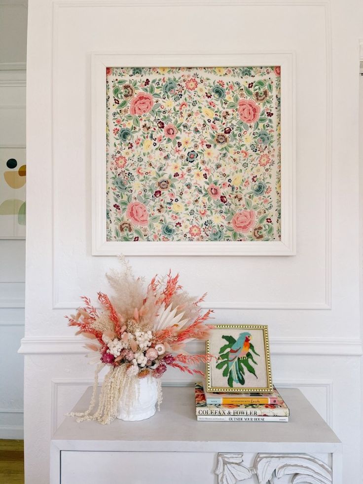 How to Display a Silk Scarf Floral wall art with a vibrant bouquet and bird artwork on a decorated table. Bright and artistic home decor display. | Sky Rye Design Floral wall art with a vibrant bouquet and bird artwork on a decorated table. Bright and artistic home decor display.
