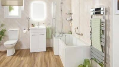 Modern bathroom with white fixtures, wood floor, and green accents, featuring a bathtub, vanity, toilet, and towel rack.