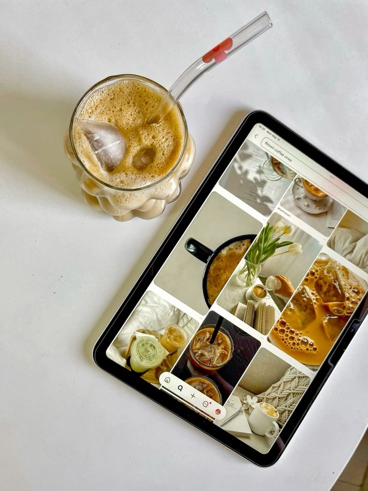 Iced coffee with straw beside a tablet displaying coffee drink images on a white surface.