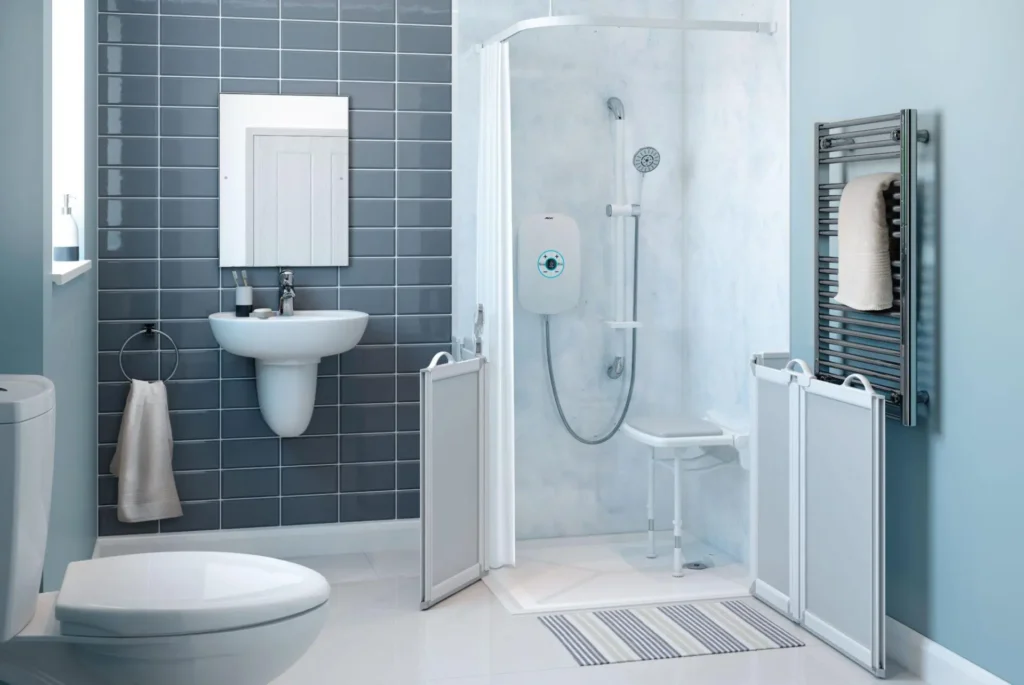 Modern accessible bathroom with walk-in shower, foldable chair, towel rack, toilet, and sink.