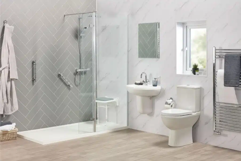 Modern bathroom with walk-in shower, sink, and toilet; features gray tile and wood flooring.