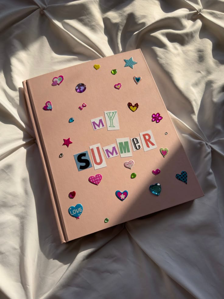 Decorated scrapbook titled My Summer on fabric, adorned with colorful stickers and gems.