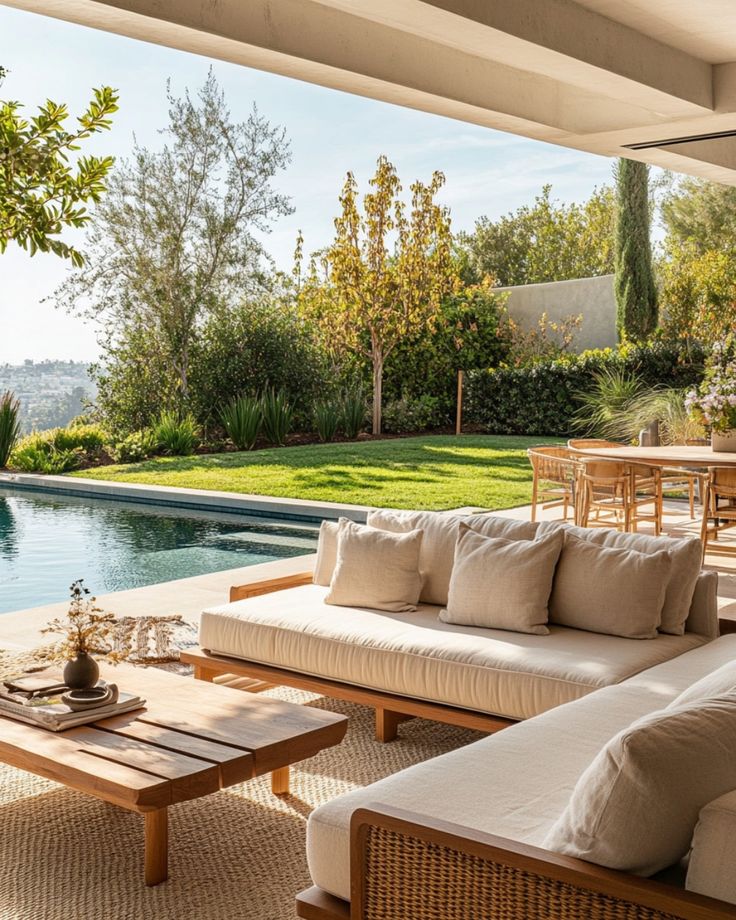 Modern patio with cozy seating and pool in lush garden setting, ideal for outdoor relaxation and entertainment.
