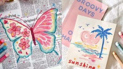 Colorful butterfly art on newspaper and beach sunset drawing with palm tree, set beside pastel chalks and notebooks.