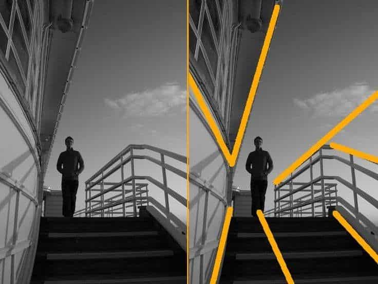 Man walking down stairs, highlighted lines emphasize structure, against a cloudy sky backdrop. Black and white photo. Framing Photography