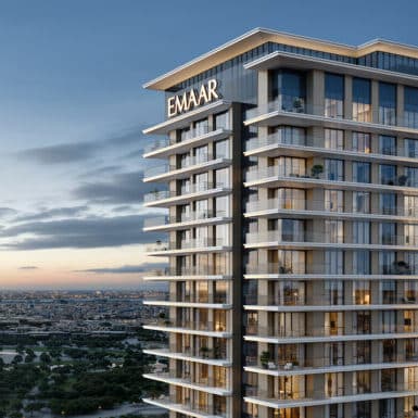 Modern Emaar building with cityscape view at sunset, featuring sleek architecture and expansive windows.