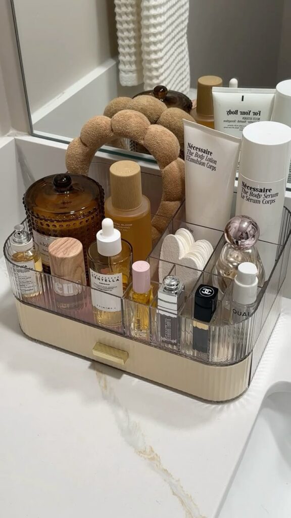Bathroom essentials arranged neatly in an organizer, featuring skincare, lotions, and perfumes on the counter.