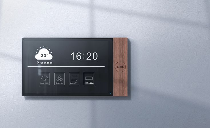 Smart home control panel displaying time, weather, and device icons on a wall, featuring sleek wood and black design.