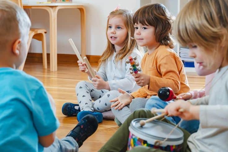 Children enjoying a music class, playing percussion instruments together in a bright classroom setting.