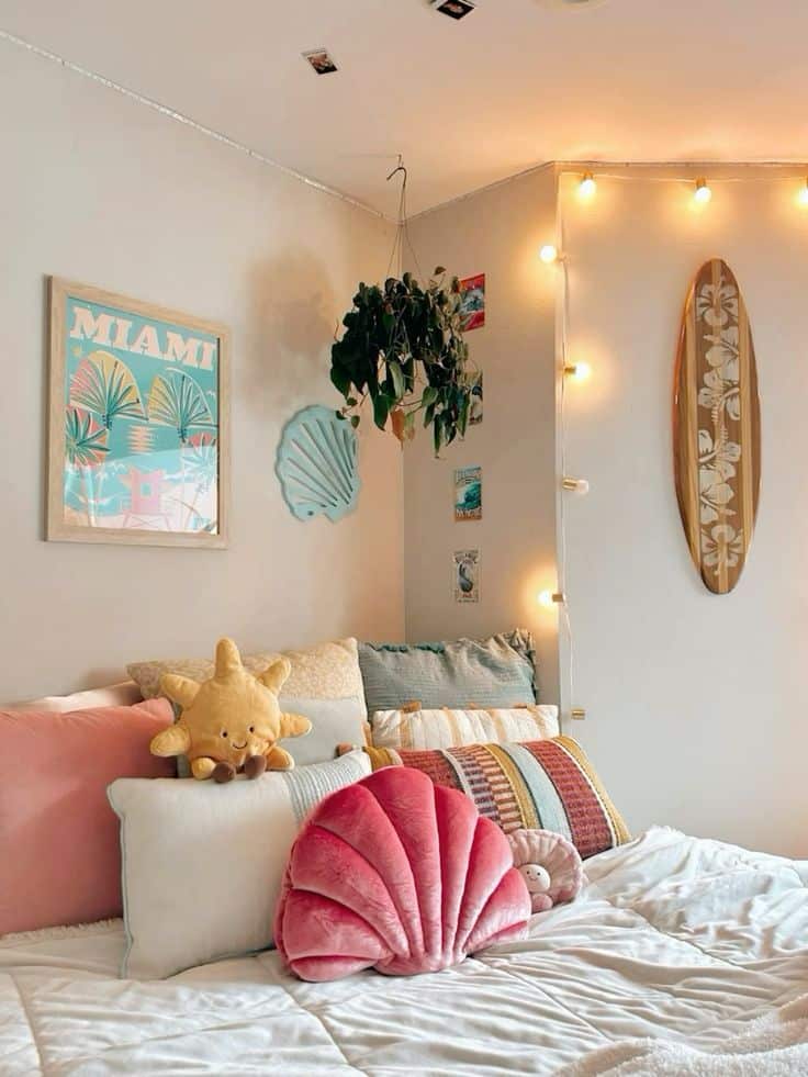 Cozy bedroom decor with colorful pillows, surfboard, hanging plant, fairy lights, and a Miami poster on the wall.