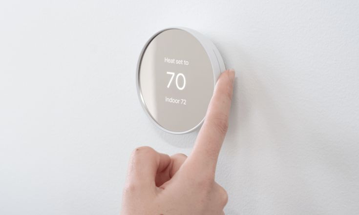 Take Control of Your Comfort_ Unleashing the Power of Smart Thermostats Person adjusting smart thermostat on wall, set to 70 degrees, displaying indoor temperature 72. | Sky Rye Design Person adjusting smart thermostat on wall, set to 70 degrees, displaying indoor temperature 72.