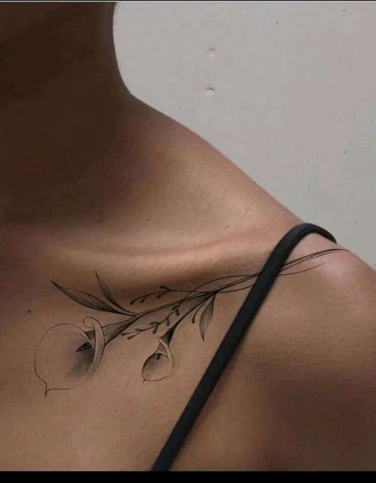 Tattoo Floral tattoo on shoulder with black ink, featuring delicate flowers and leaves, highlighting elegant skin art design. | Sky Rye Design Floral tattoo on shoulder with black ink, featuring delicate flowers and leaves, highlighting elegant skin art design.