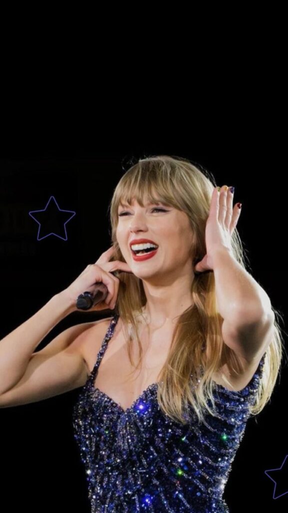 A woman in a sparkling dress performs on stage, smiling and holding a microphone with a starry black background.
