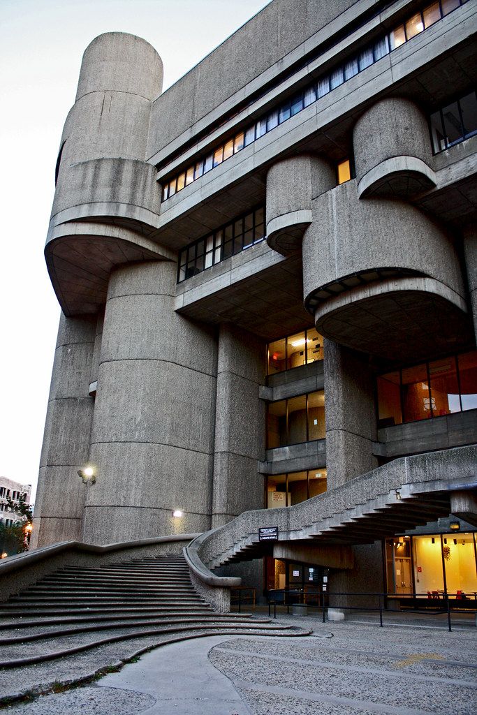 Brutalist architecture building with curved stairways and concrete textures, showcasing modern design elements.