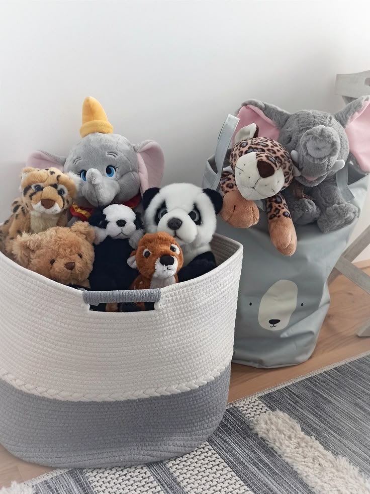 Plush animals in baskets, featuring elephants, panda, and more, on a cozy rug in a child's room.