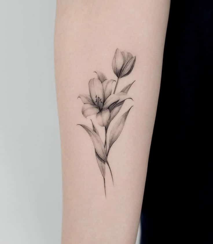 Minimalist lily flower tattoo on inner forearm, detailed black ink design.