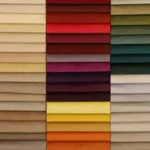 Colorful fabric swatches arranged in rows, showcasing a vibrant mix of reds, greens, yellows, and neutrals.