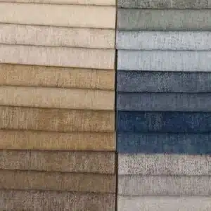Array of fabric swatches in various earth tones and blues, showcasing texture and color variations for interior design.