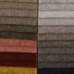 Fabric swatches in neutral, brown, red, and yellow tones, arranged neatly for upholstery or interior design.