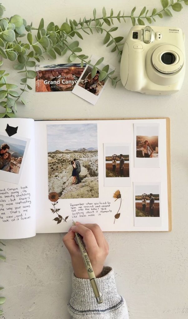 Handwriting memories in a scrapbook with photos, polaroid camera, Grand Canyon ticket, and leaves.