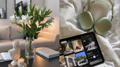 Modern living room with white lilies, books, and a cozy setup featuring headphones and a tablet on a bed.