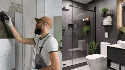 Man tiling a bathroom wall beside a modern, sleek bathroom interior with black glass shower and white fixtures.