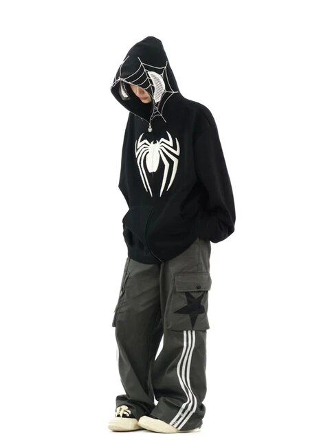 Person wearing a black spider-themed hoodie and gray cargo pants with star design, standing in a relaxed pose.