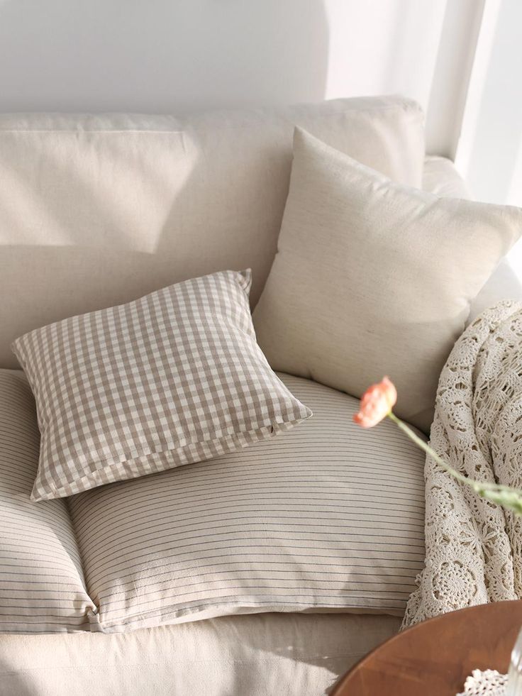 Washed Natural 2 Types 5 Sizes Cushion Cover Cozy beige sofa with checkered and striped pillows, crochet blanket, and soft lighting for a warm, inviting living space. | Sky Rye Design Cozy beige sofa with checkered and striped pillows, crochet blanket, and soft lighting for a warm, inviting living space.