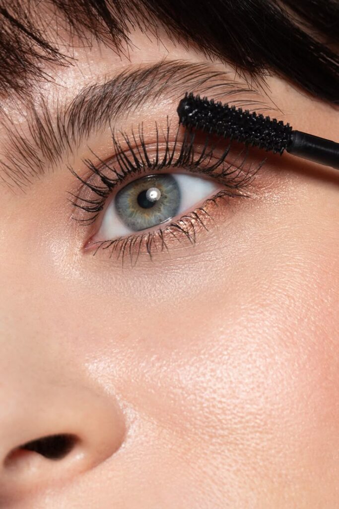 Close-up of an eye with mascara application, emphasizing long, thick lashes and a flawless makeup look.