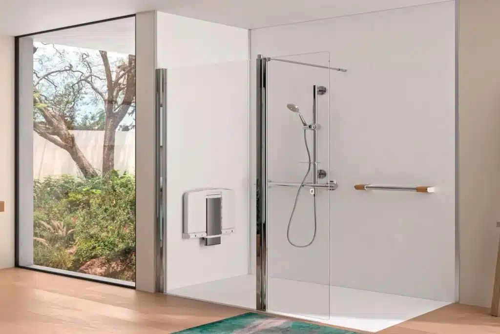 Modern walk-in shower with glass doors, white walls, and garden view through large window.