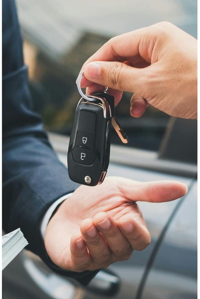 Workers share 6 signs that will give you away at the car dealership Handing over car keys, symbolizing car sale or rental transaction, close-up of hands exchanging keys. | Sky Rye Design Handing over car keys, symbolizing car sale or rental transaction, close-up of hands exchanging keys.