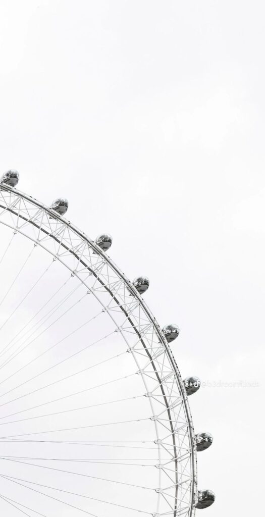 a6859b560061d818a348937f464b0d1f Ferris wheel against a cloudy sky, showcasing its pods and metal structure in a minimalistic design. | Sky Rye Design Ferris wheel against a cloudy sky, showcasing its pods and metal structure in a minimalistic design.