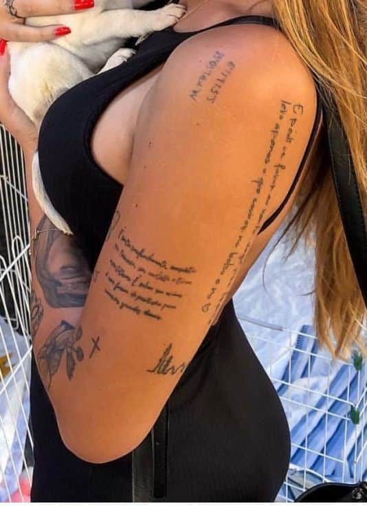 c2430da2cd567c7e9ef510ce76a96897 Woman with tattooed arm holding a small dog, wearing a black dress. | Sky Rye Design Woman with tattooed arm holding a small dog, wearing a black dress.