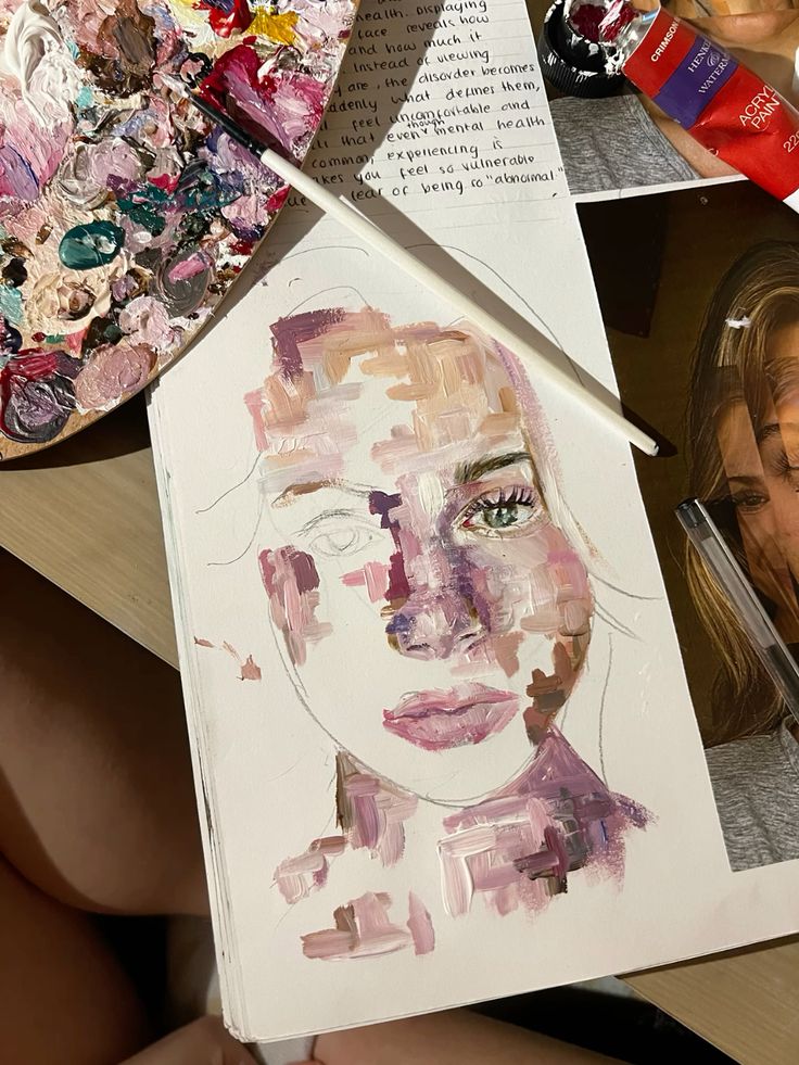 Abstract portrait painting in progress with vibrant palette, brush, and notes in the background.
